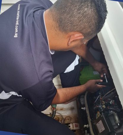 Technician working inside a boat compartment